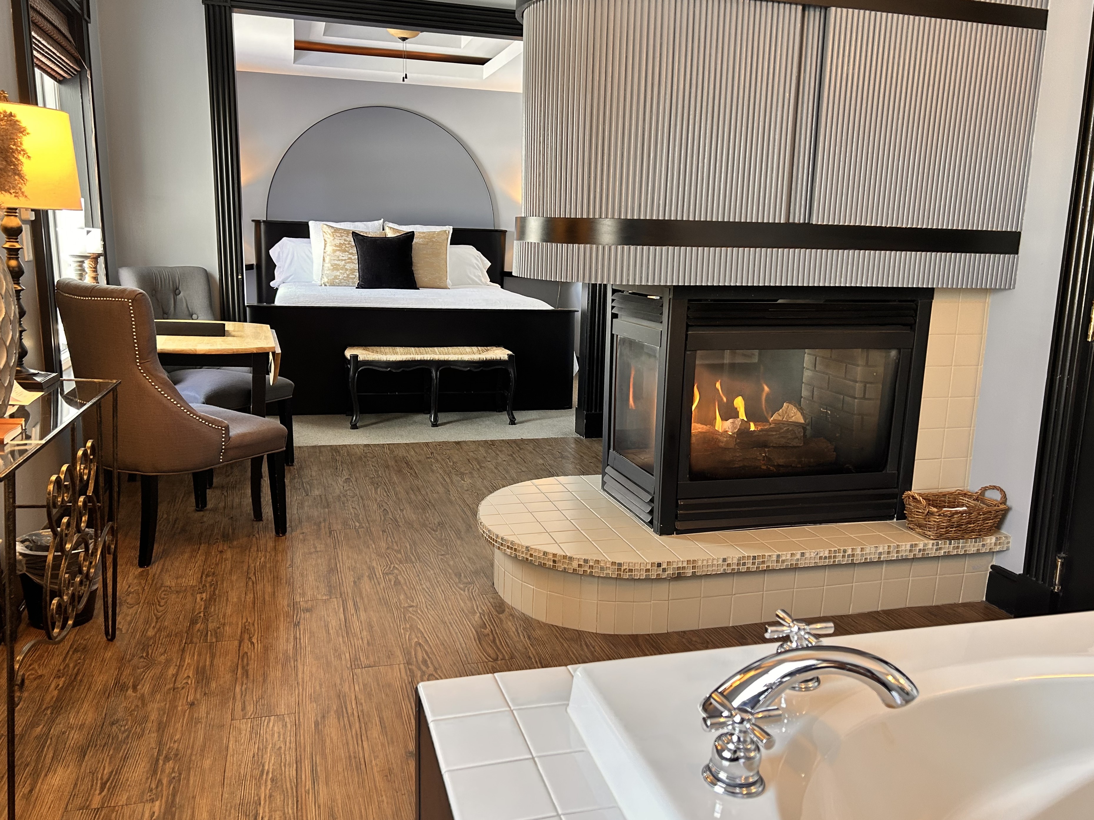 Suite with king bed, two person jetted tub, fireplace, seating area, with a king size bed.