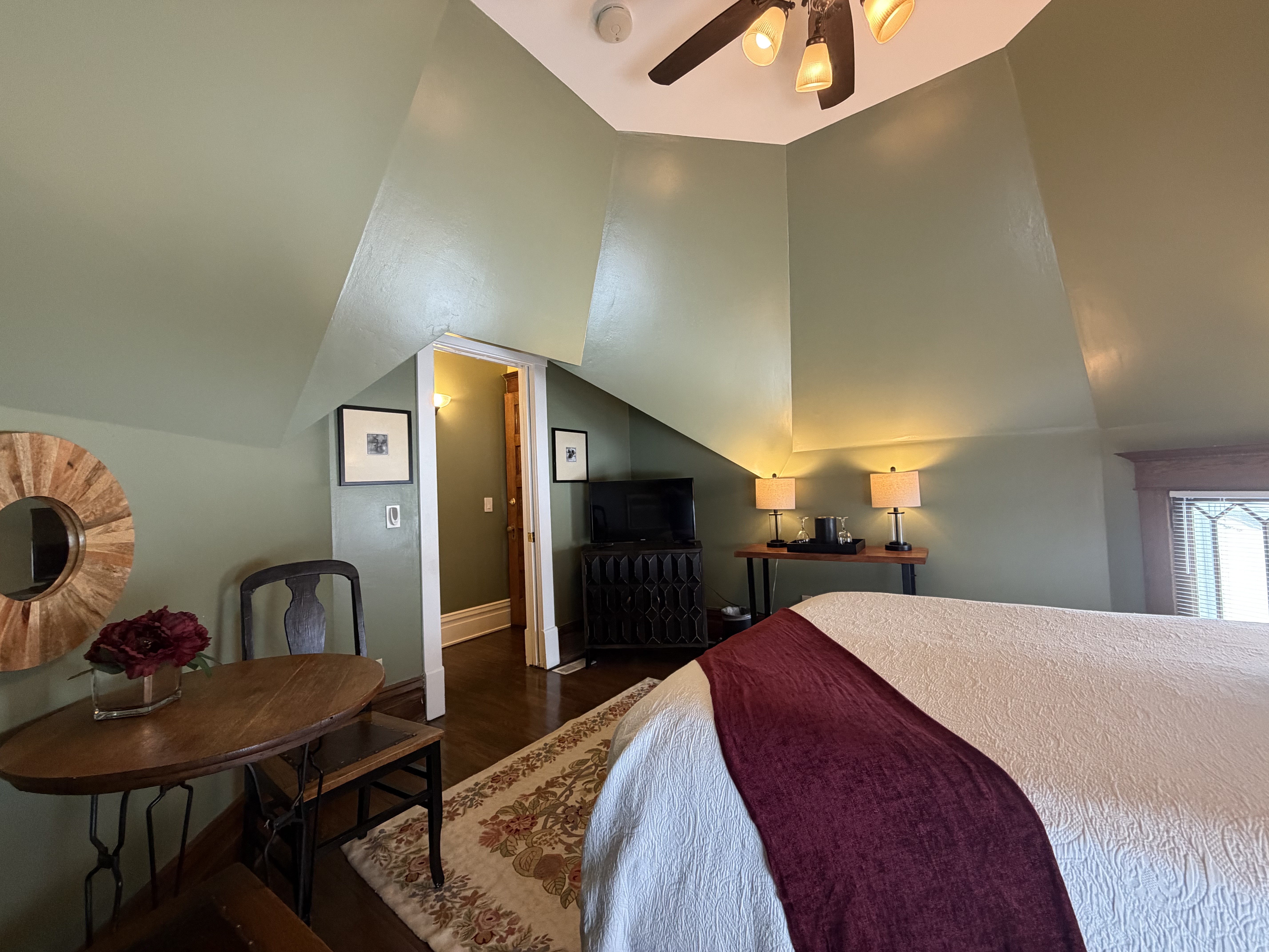 Room inside an eight sided turret, with a queen bed, seating area, cable TV.