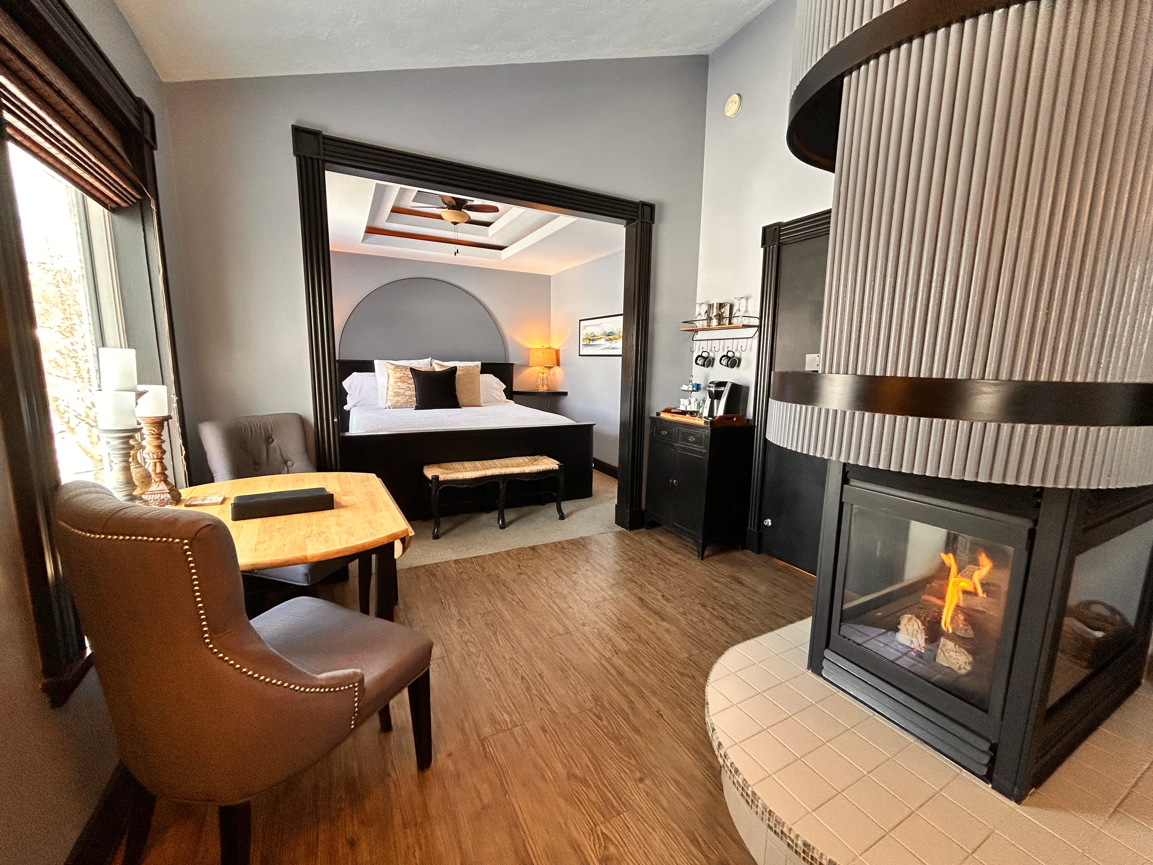 Suite with a king bed, cove ceiling, table and chairs, champagne tray