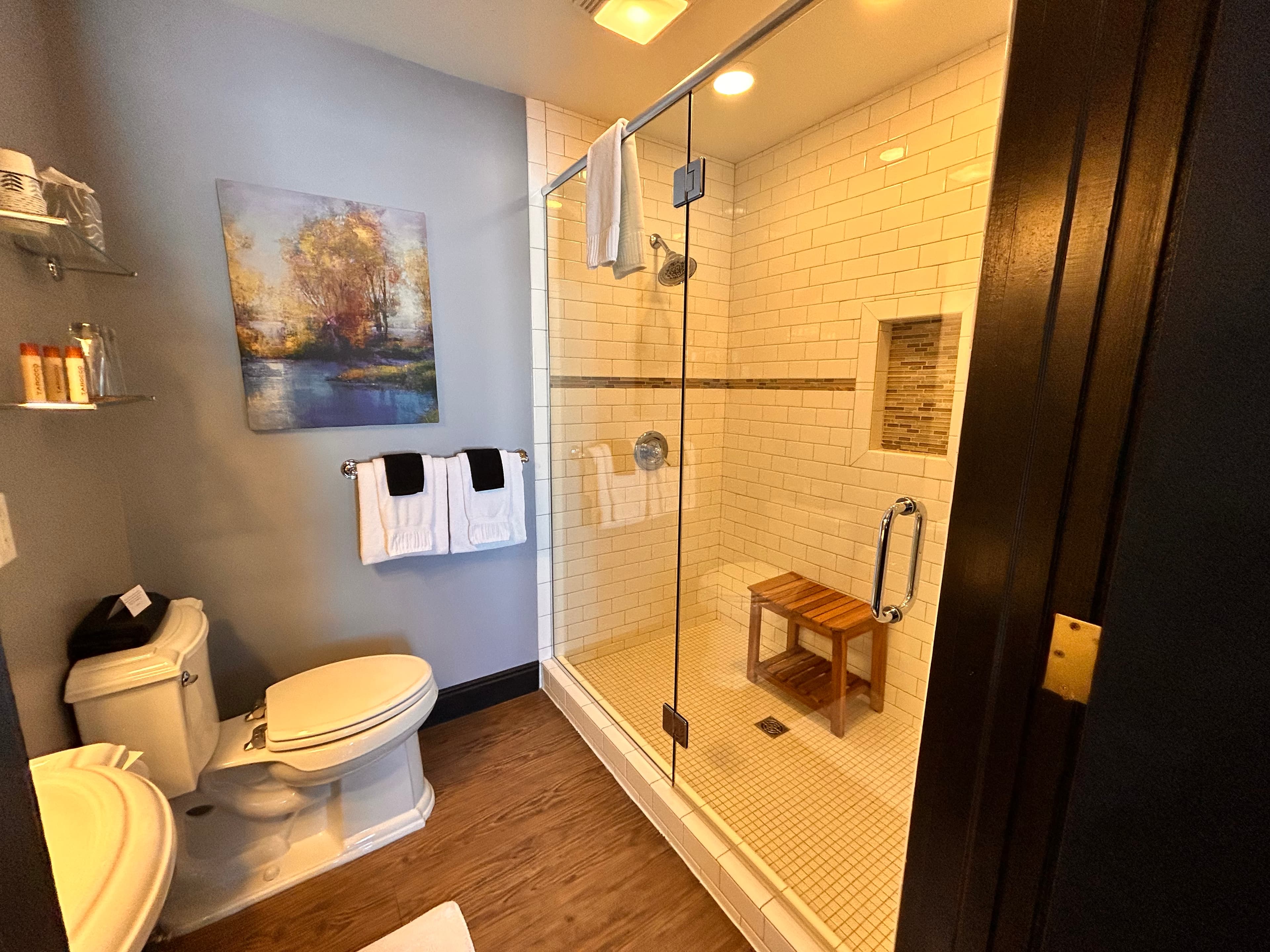 Suite with Two person mosaic tiled shower with glass doors.