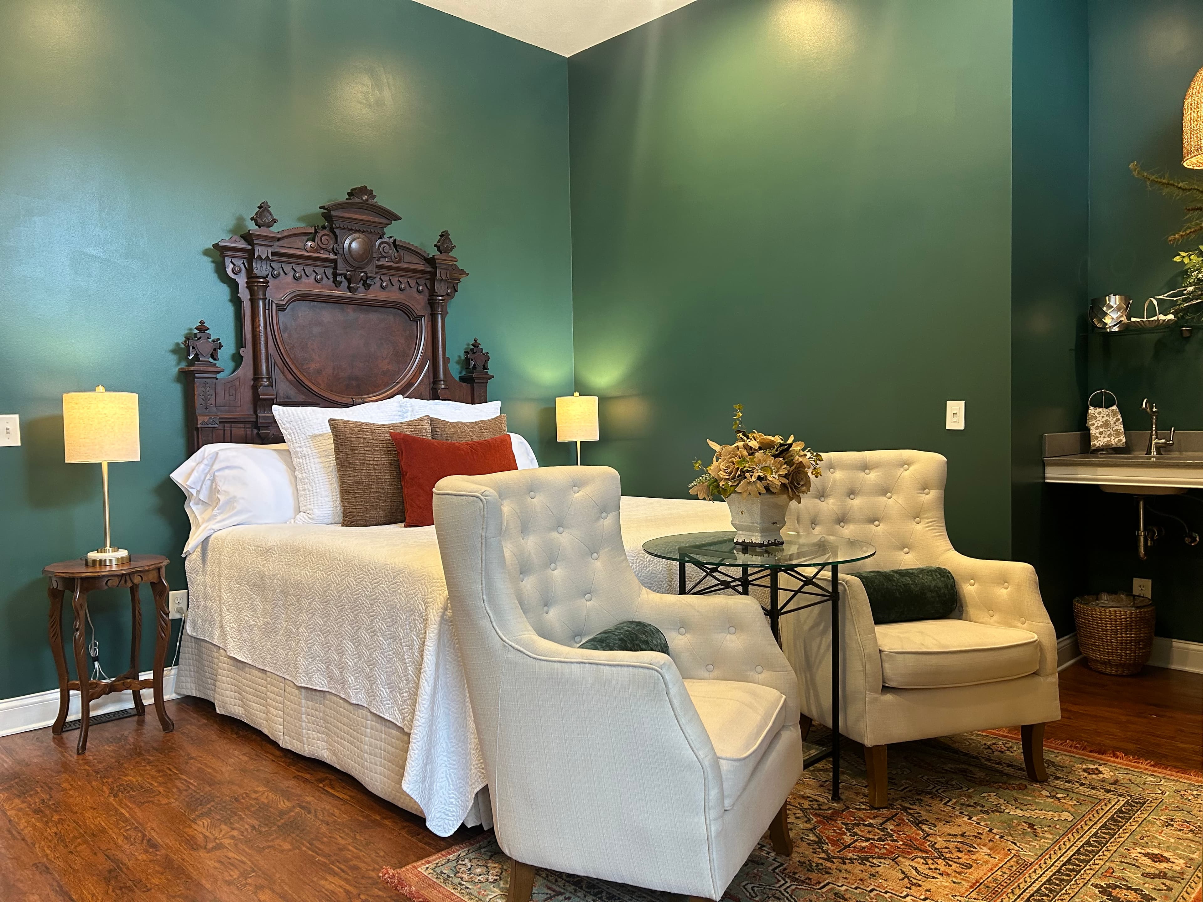 Suite with an Antique king bed, seating area, large fire place and television.