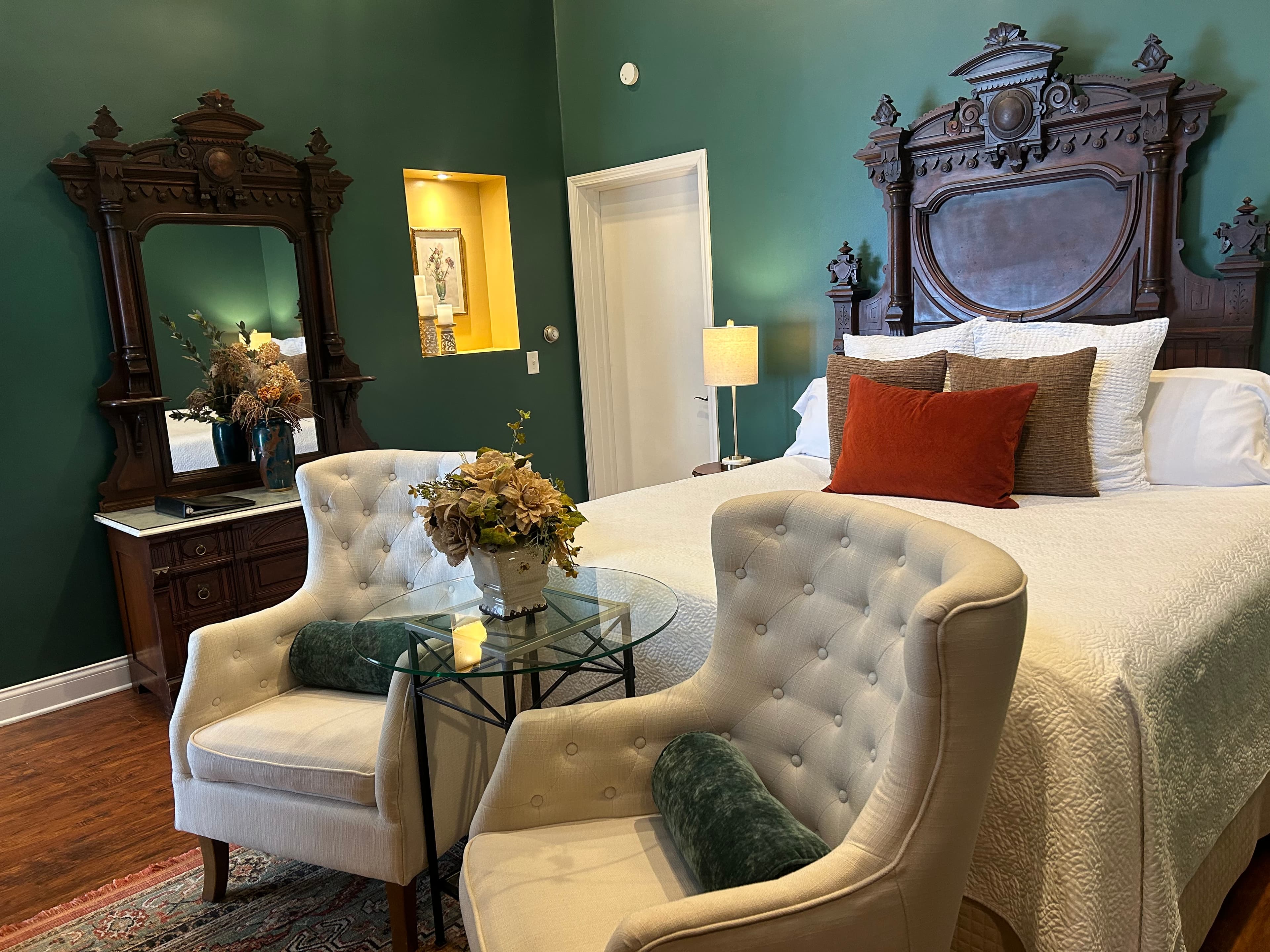Suite with a king size bed, bench and sitting area.