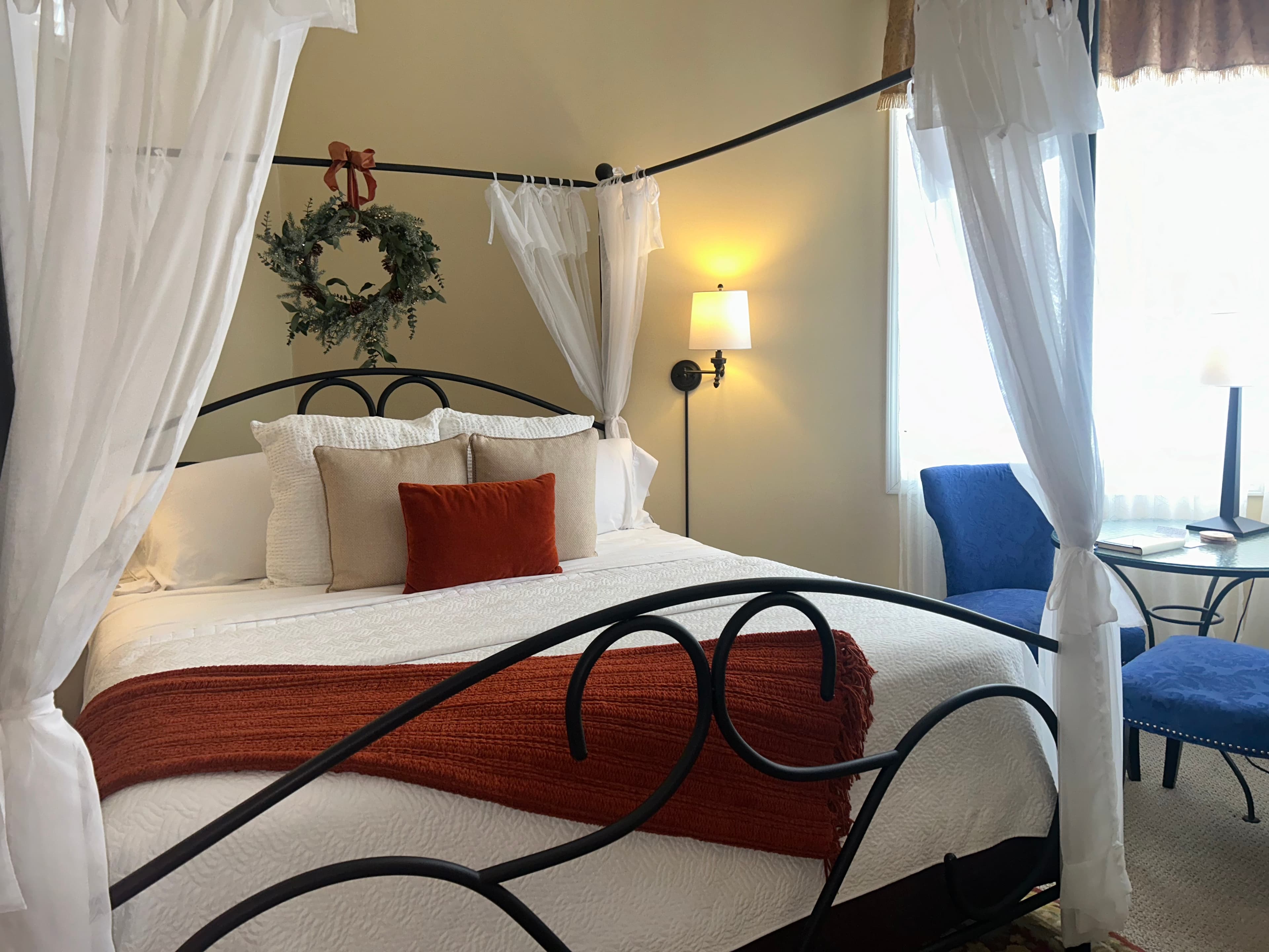 Suite with a king canopy bed, seating area and fireplace