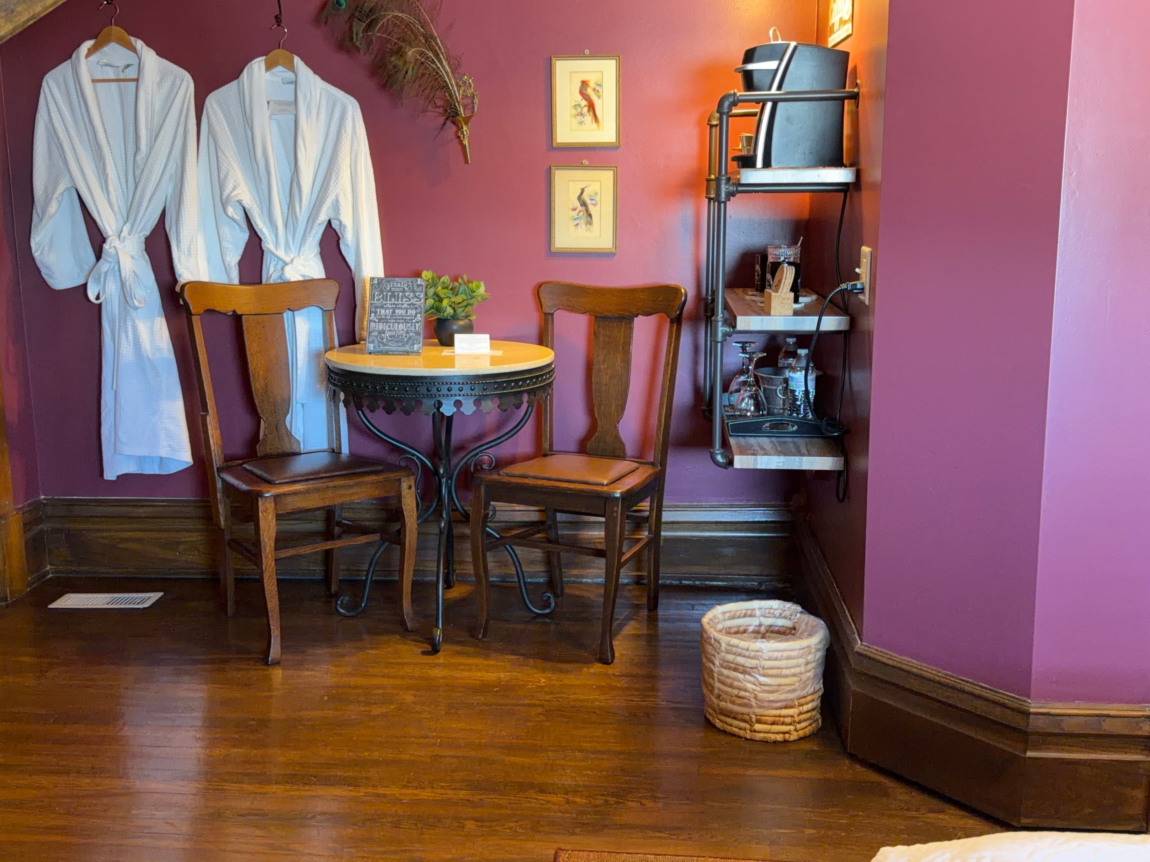 Room with a queen bed, angled ceilings with a unique picture window.