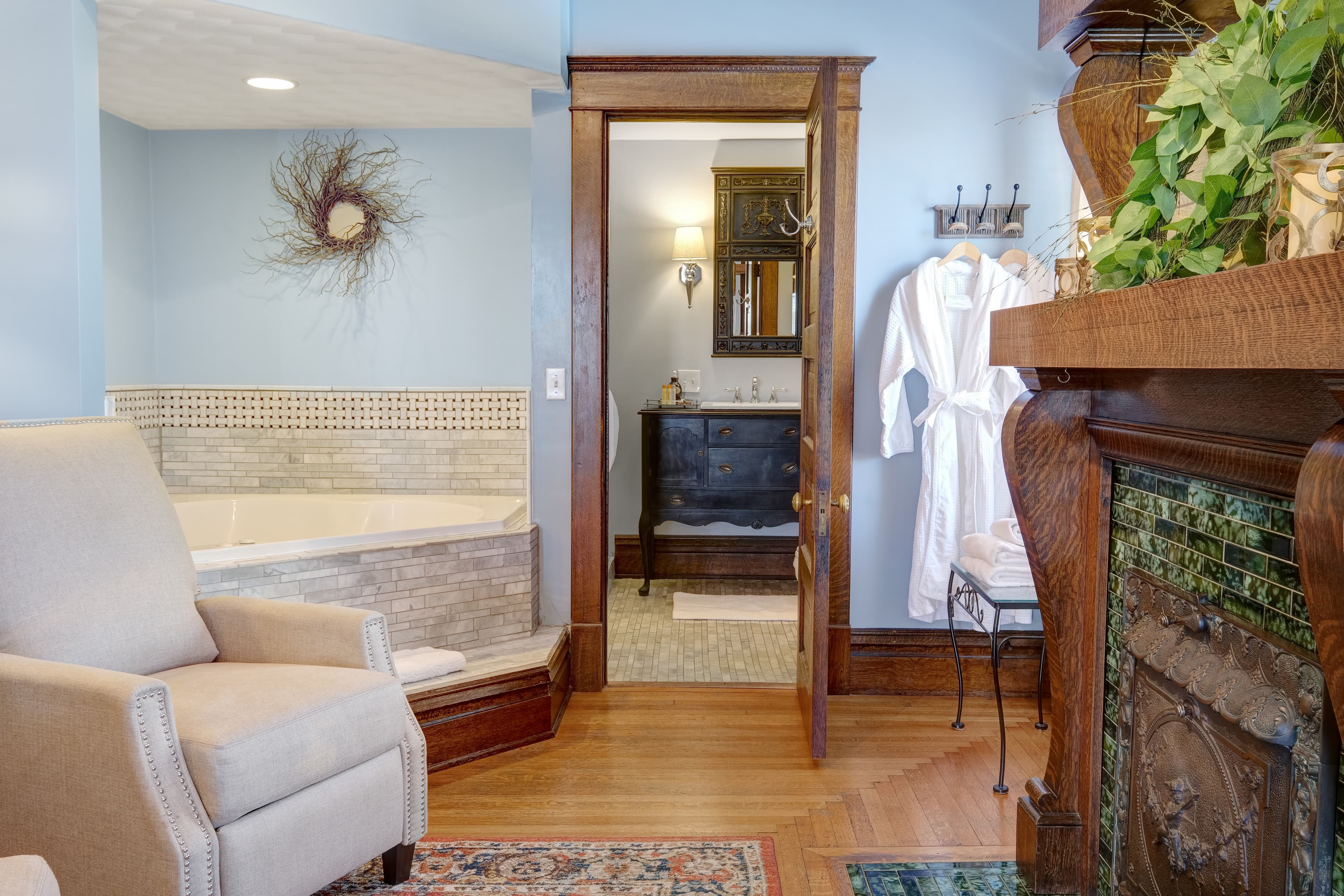 Suite with a two person jetted tub, chairs, fireplace, robes, ensuite bath