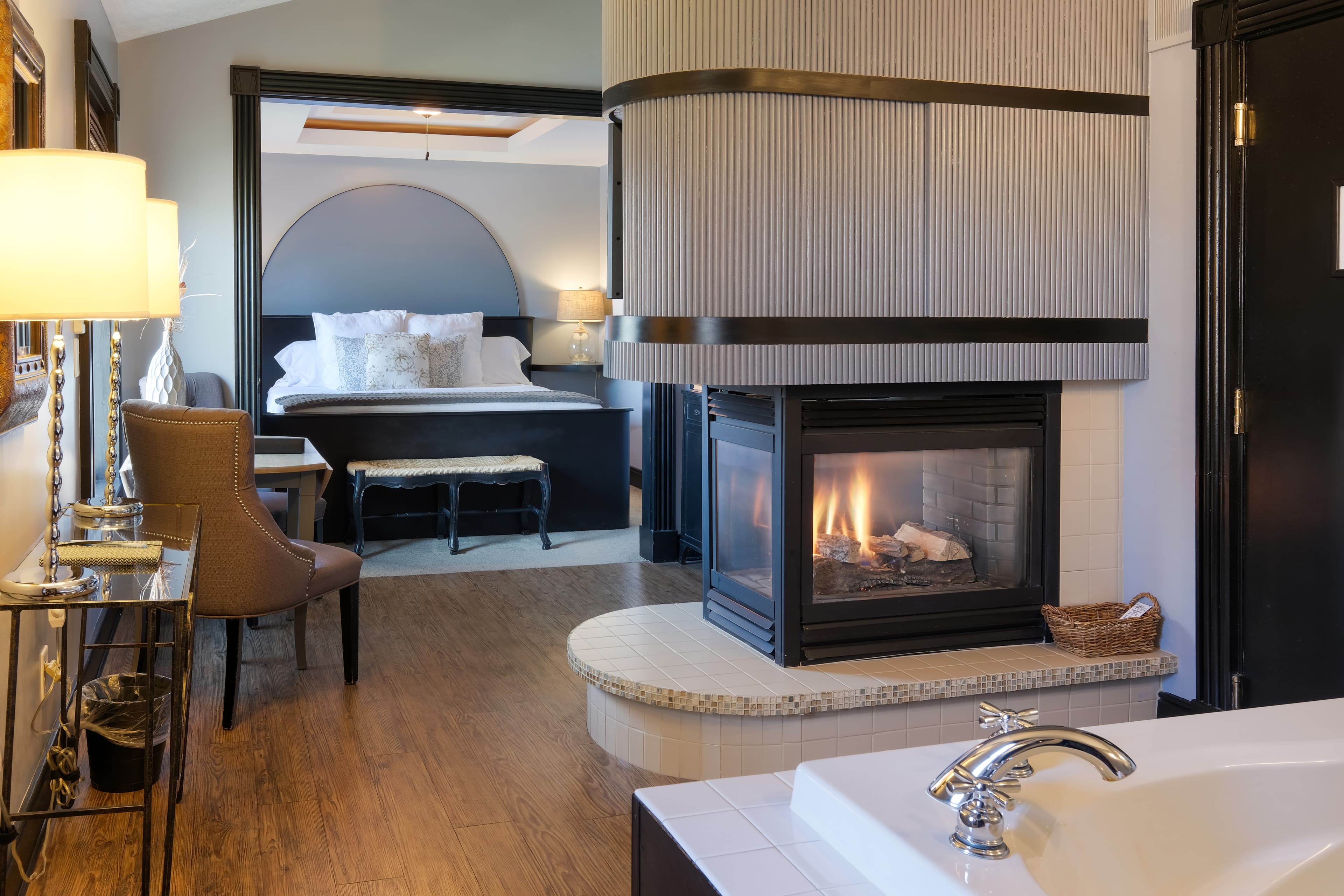 Suite with king bed, two person jetted tub, fireplace, seating area, with a king size bed.