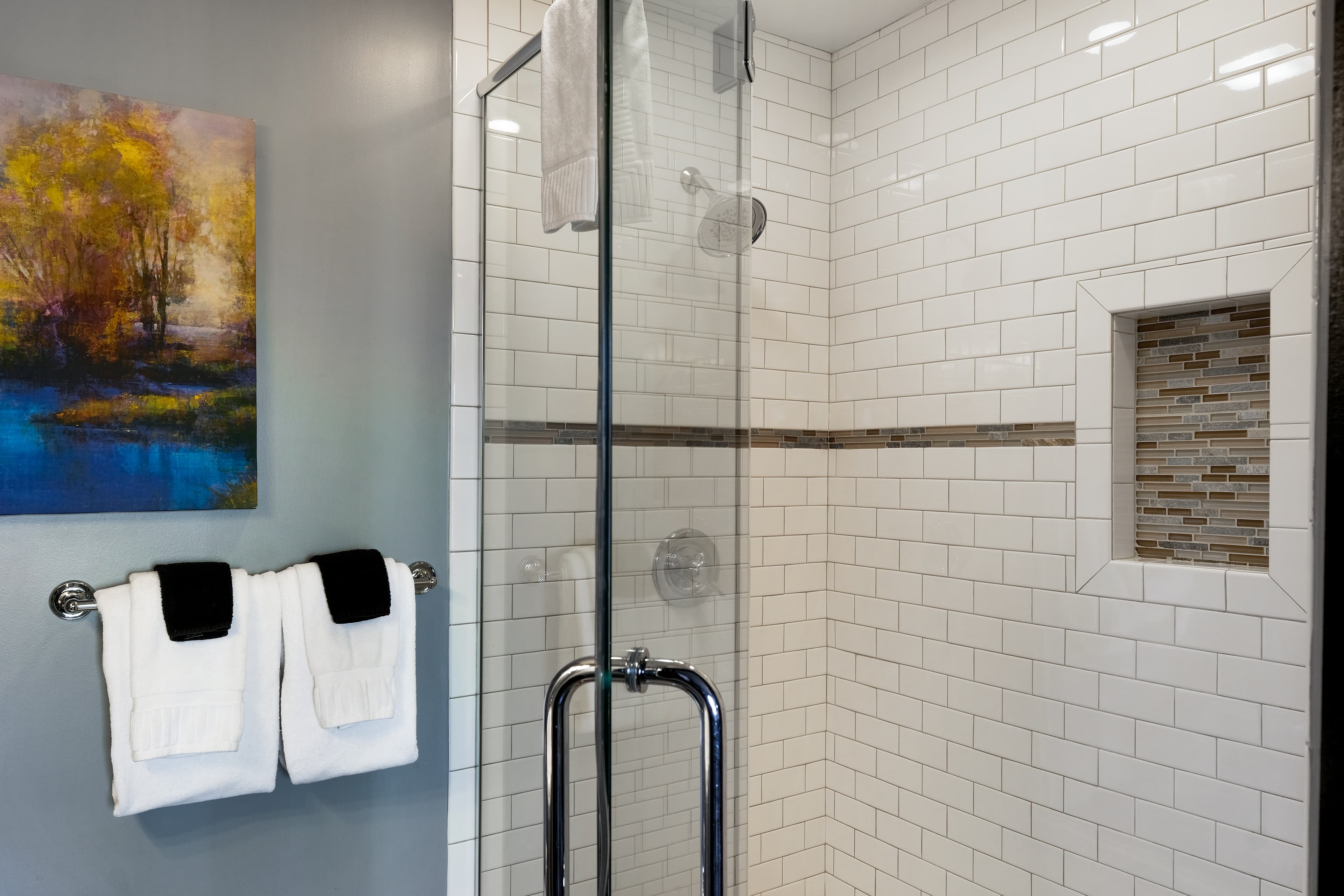 Suite with Two person mosaic tiled shower with glass doors.