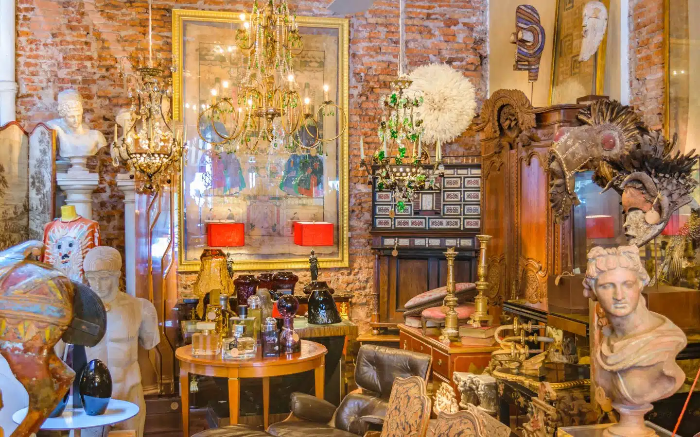 A vintage interior filled with artwork, sculptures, and eclectic decor against a brick wall backdrop. A vintage interior filled with artwork, sculptures, and eclectic decor against a brick wall backdrop.