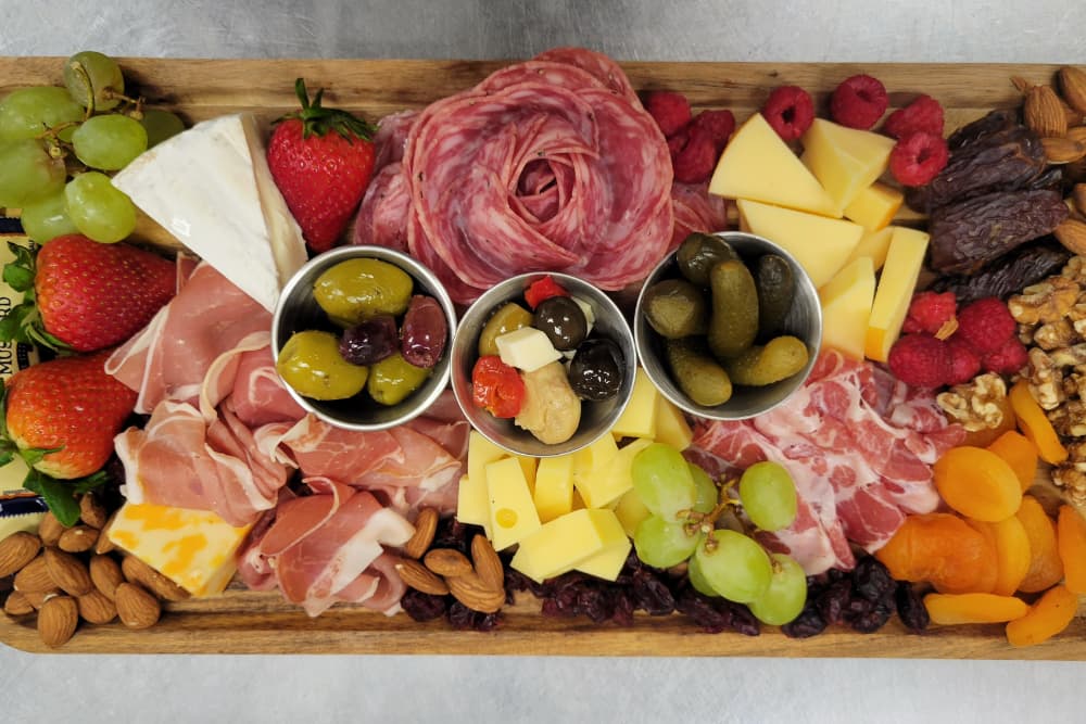 A vibrant charcuterie board featuring a variety of meats, cheeses, fruits, nuts, and olives.