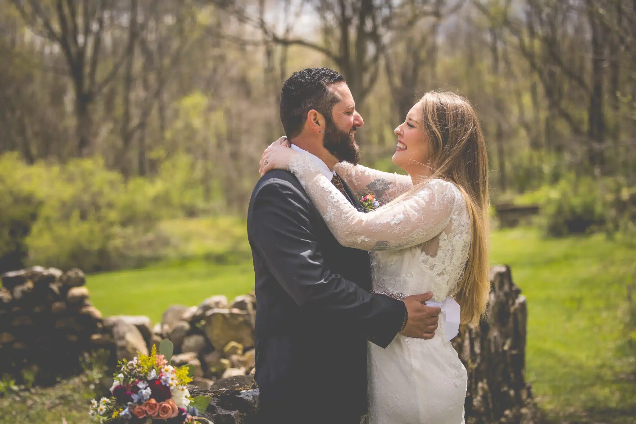 A couple joyfully embraces in a lush outdoor setting, celebrating their love.