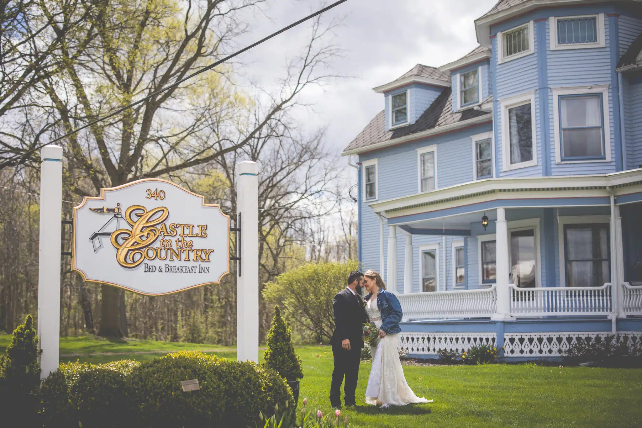 A newlywed couple shares a kiss in front of the Castle in the Country Bed & Breakfast Inn.