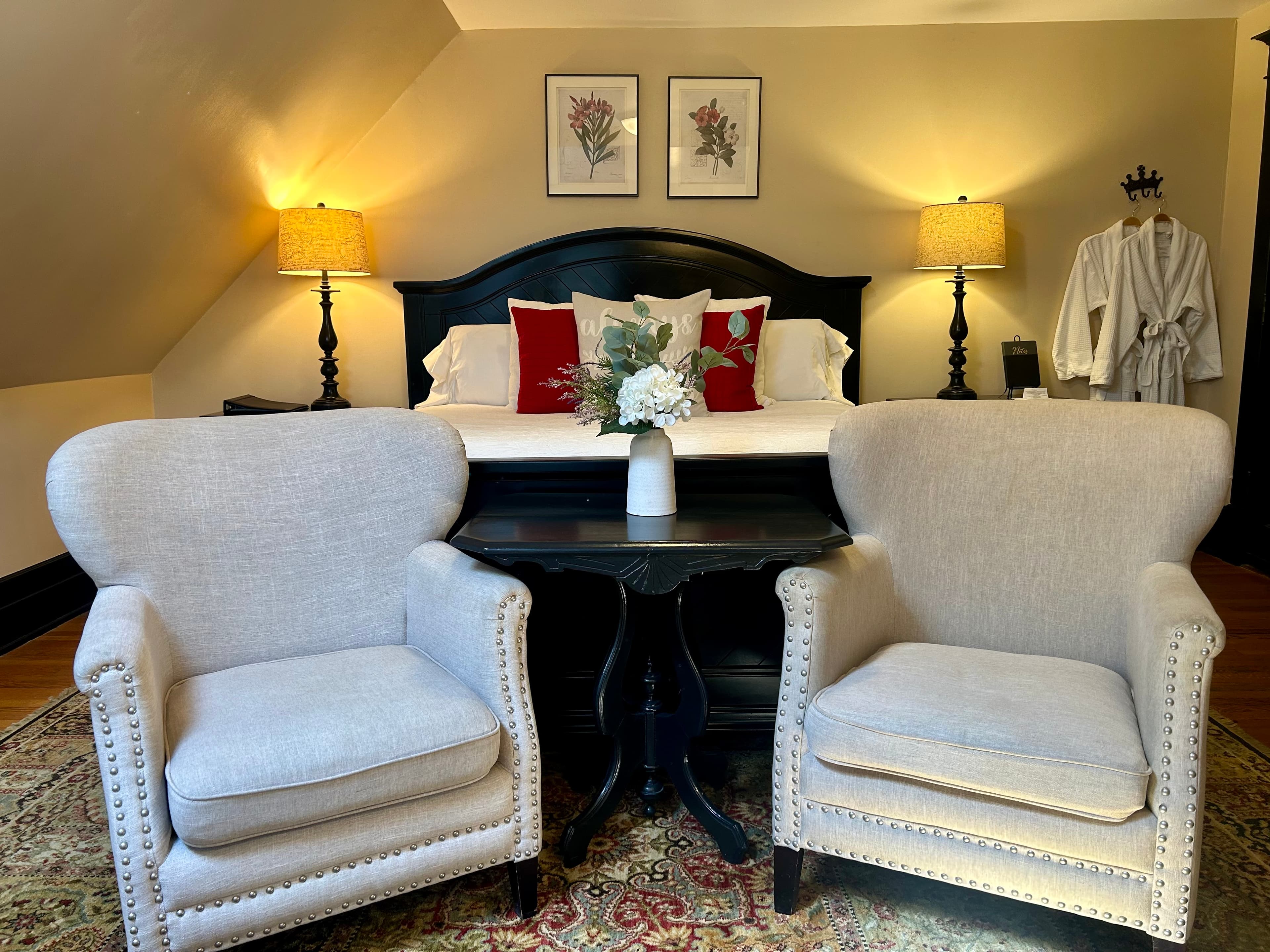 Suite with king bed, seating area, and plush white robes