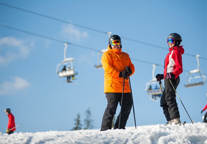 Skiiers Standing in the Snow Under Lift