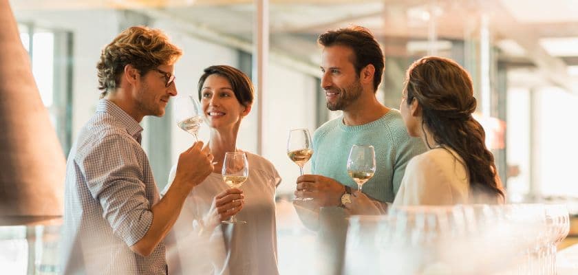 Two couples enjoying a tasting experience at a winery.