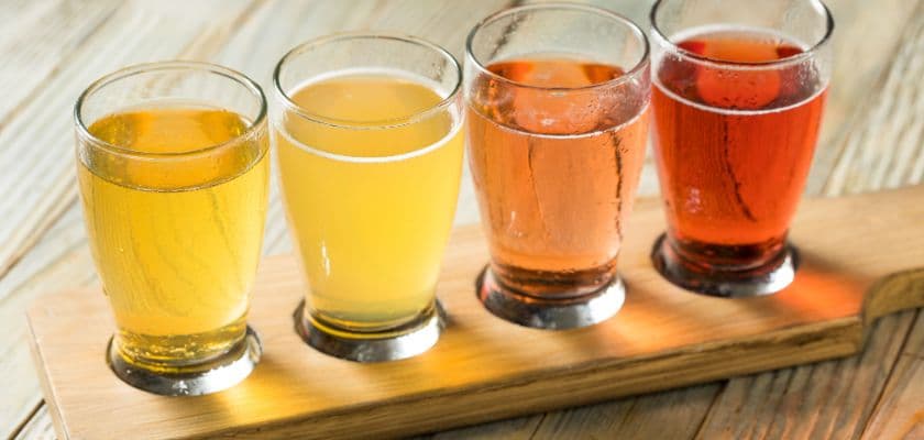 A flight of hard cider on a wooden paddle, prepped for a cider tasting.