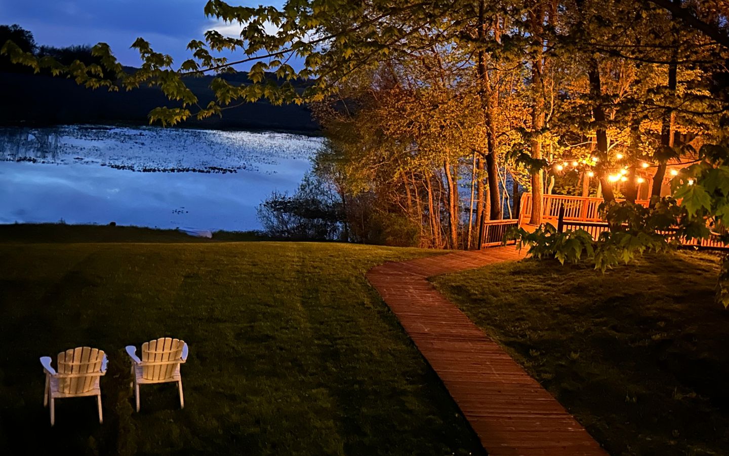 Adirondack chairs and a lighted gazebo next to the pond