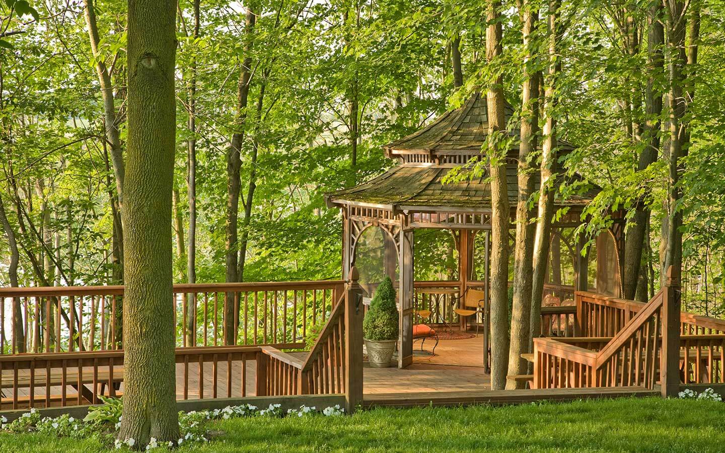 gazebo deck in the summertime with green trees surrounding