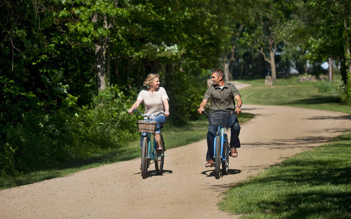 Couple riding bikes on a dirt path