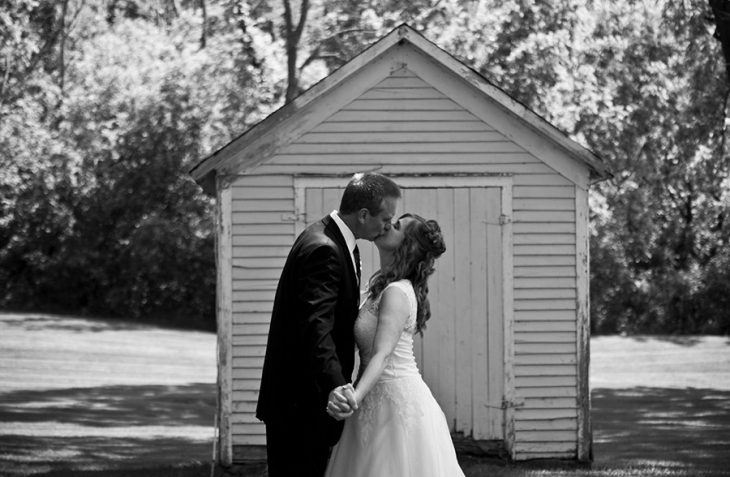 Wedding couple kiss in yard