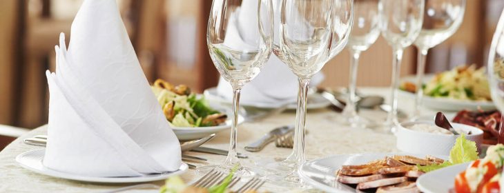 Wine glasses and plates of salad on a table