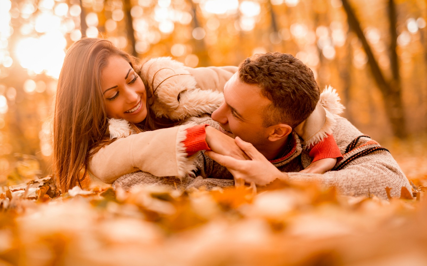 couple lying in the fall leaves