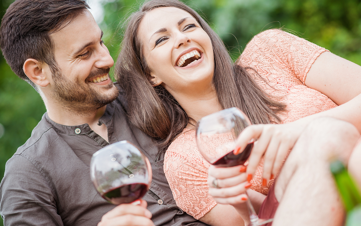 couple laughing with glasses of wine