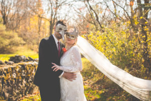 halloween wedding couple pose with masquerade masks