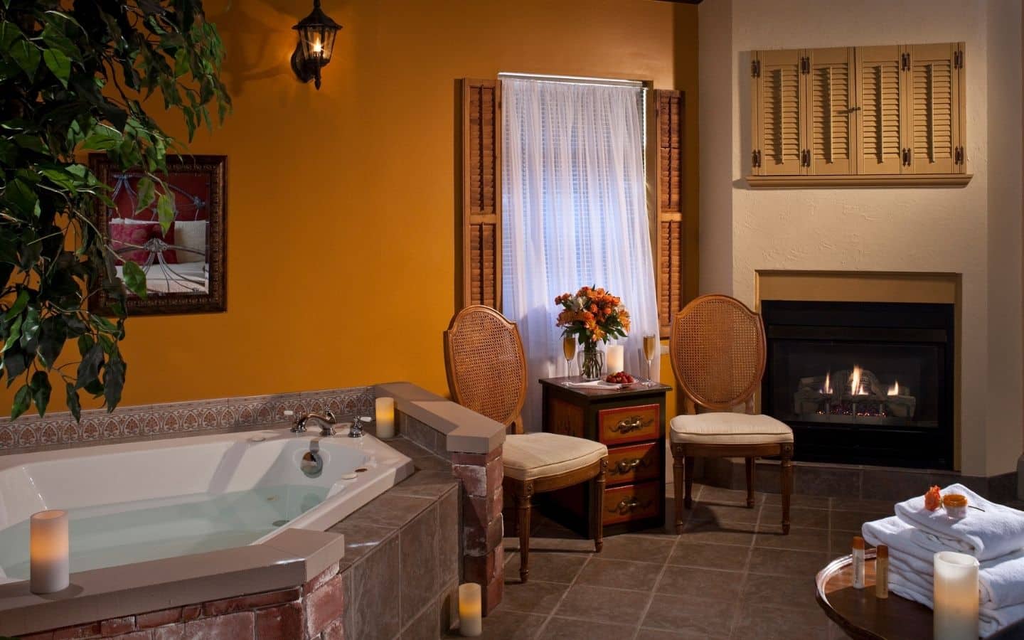 Guest room with warm tan walls, jetted tub and cozy fireplace