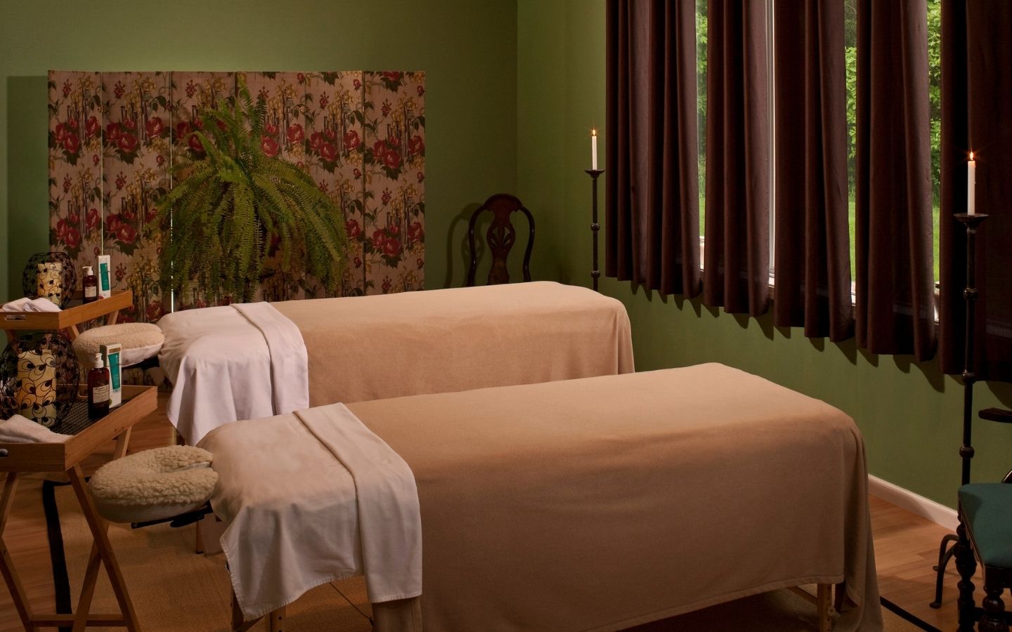 Cozy and tranquil massage room with dim lighting, two massage tablesl for couple's massages