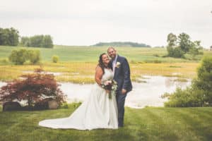wedding couple posing in front of natural pond