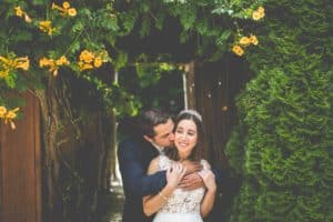 wedding couple hug under floral pergola