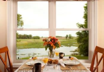 Table for two in the dining room with a view of the water outside of the window.