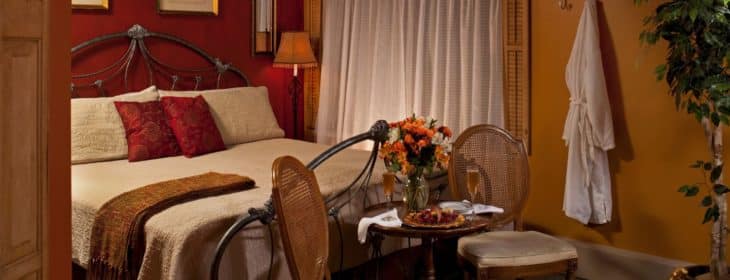 Romantic Romeo & Juliet guest rooms in warm shades of pumpkin and burgundy.