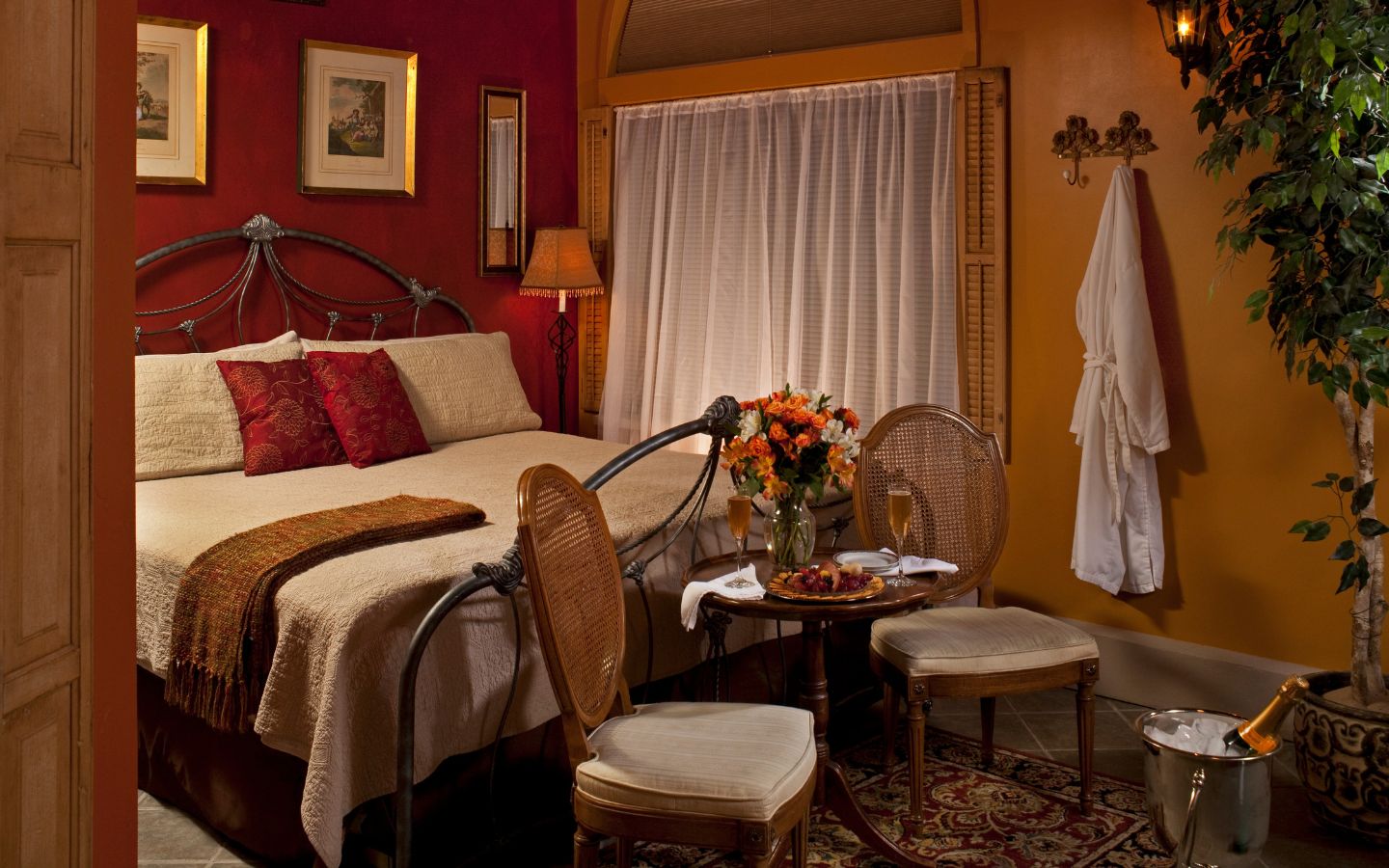 Romantic Romeo & Juliet guest rooms in warm shades of pumpkin and burgundy.