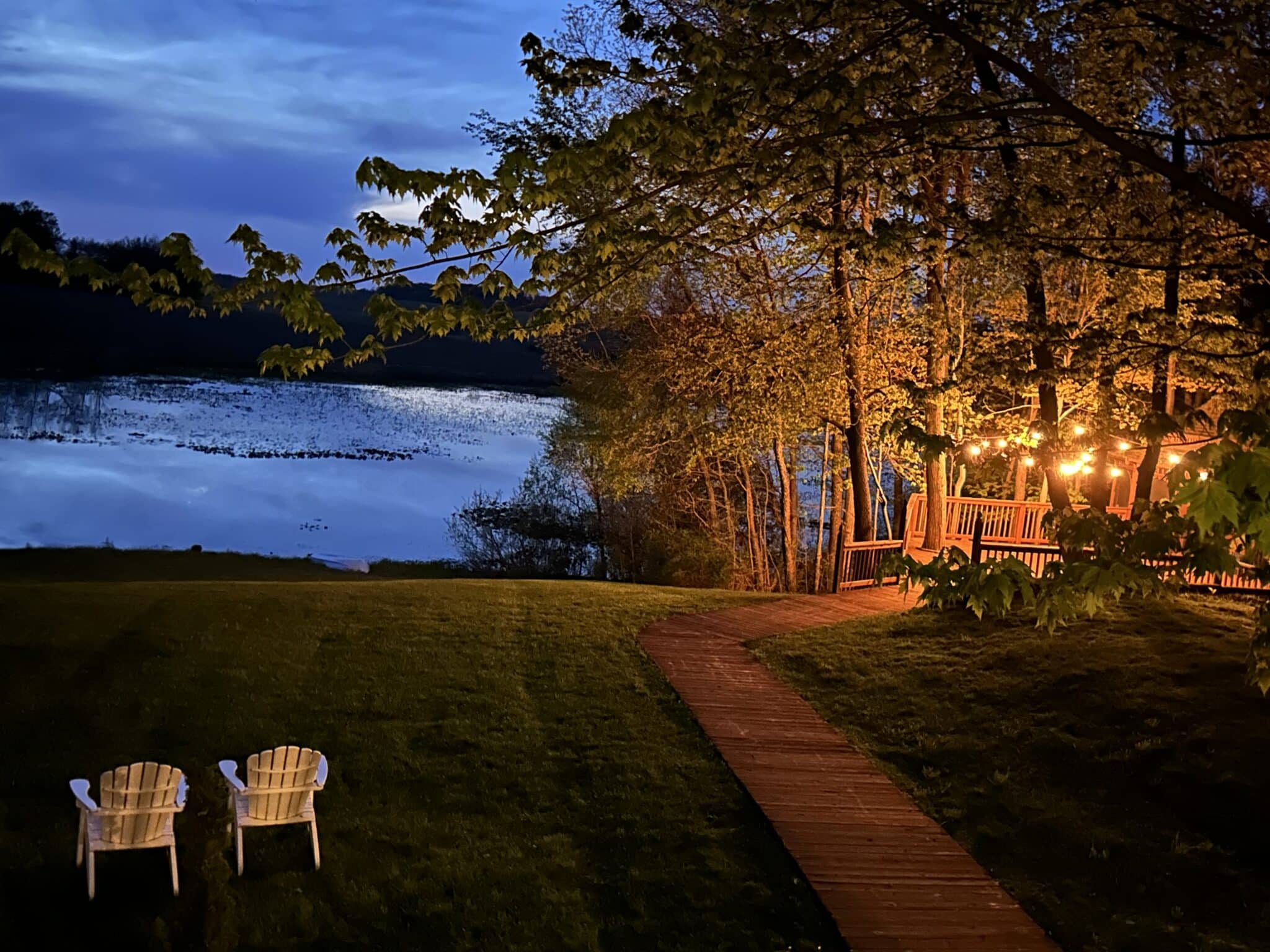 Overlooking the pond at dusk with adirondack chairs