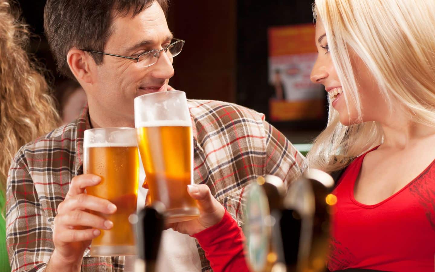 A young couple enjoying pints of beer at a bar